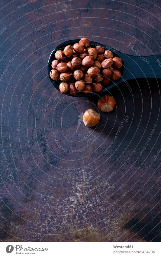 Spoon of cracked hazelnuts brown Shabby chic dark background whole wooden spoon wooden spoons copy space metal metals Hazelnut Hazel-Nut Hazelnuts Hazel-Nuts