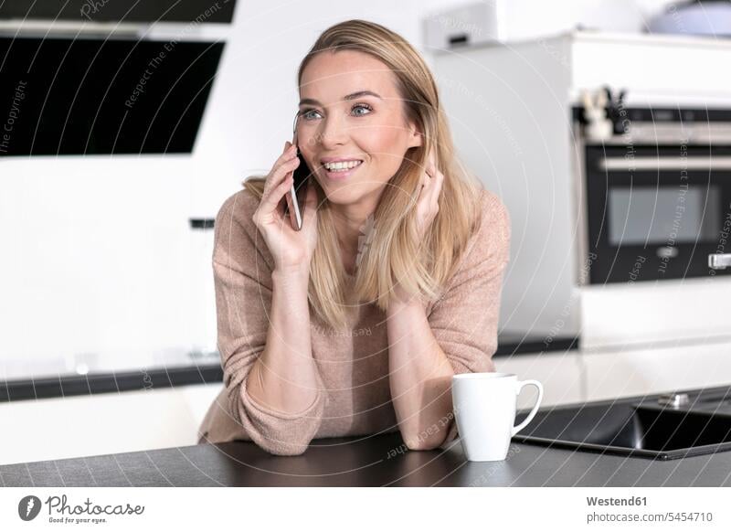 Portrait of blond woman on the phone at home call telephoning On The Telephone calling blond hair blonde hair portrait portraits females women telephone call