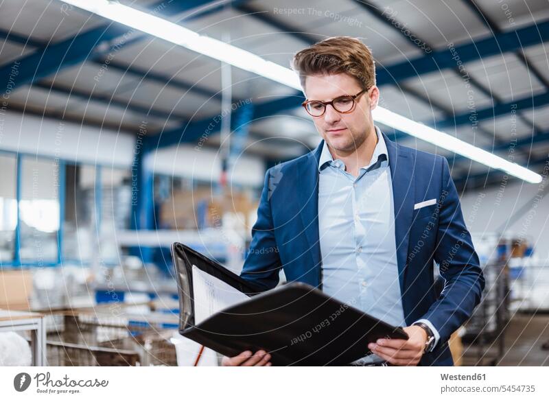 Portrait of a young manager in the shop floor, holding file standing inventory stocktaking stock control company firm Responsibility responsible one person 1