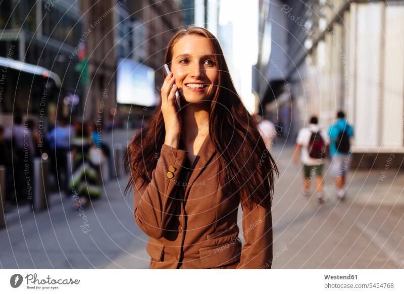 USA, New York, Manhattan, smiling young businesswoman on the phone call telephoning On The Telephone calling portrait portraits businesswomen business woman