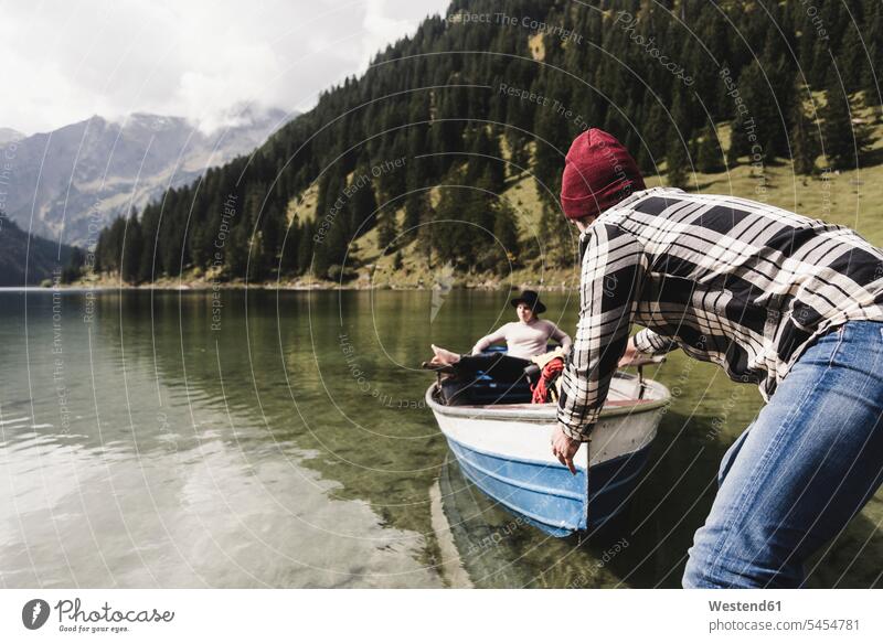 Austria, Tyrol, Alps, couple with rowing boat on mountain lake lakes twosomes partnership couples relaxed relaxation boats water waters body of water people