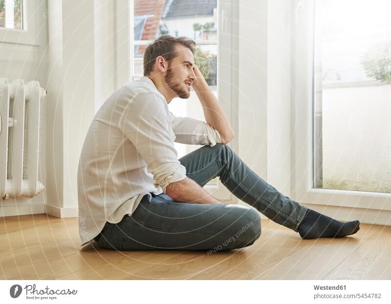 Man sitting on the floor man men males Seated Adults grown-ups grownups adult people persons human being humans human beings home at home relaxed relaxation