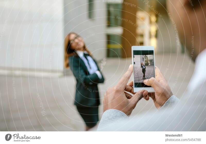 Young businessman and woman taking smart phone pictures business people businesspeople colleagues mobile phone mobiles mobile phones Cellphone cell phone