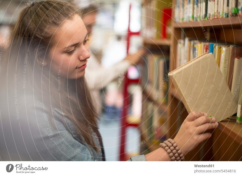 Female student at the library putting back book in book shelf pupils books schoolgirl female pupils School Girl schoolgirls School Girls education learning