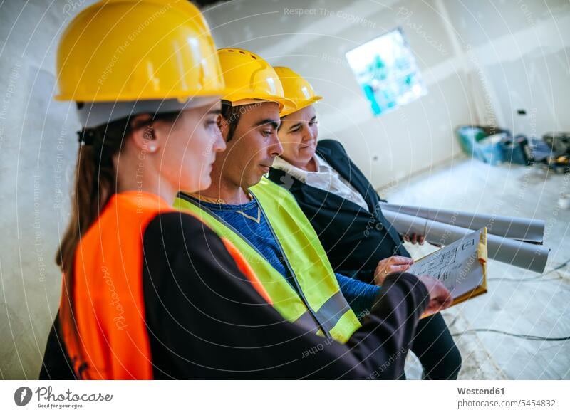 Two women and construction worker on construction site looking at plan builders Building Site sites Building Sites construction sites construction plan