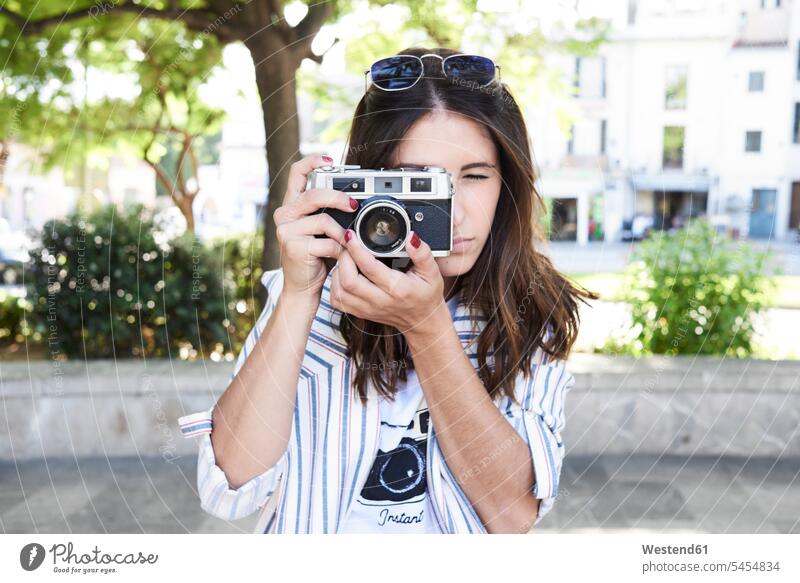 Young woman taking picture with vintage camera cameras photographing females women Adults grown-ups grownups adult people persons human being humans