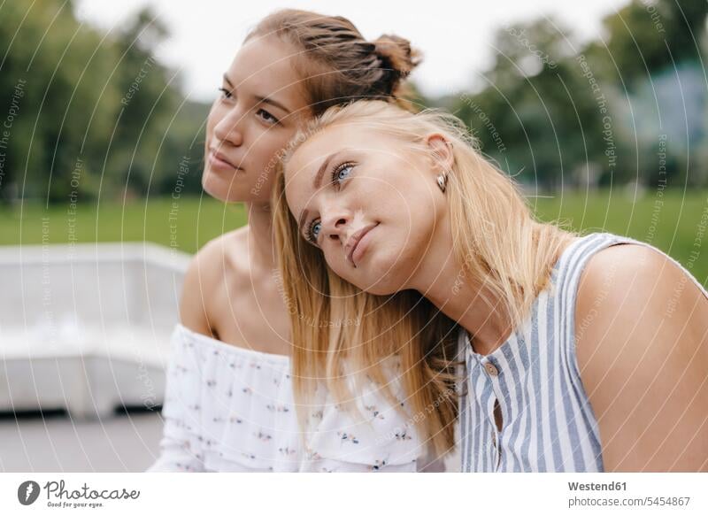 Young woman resting on female friend's shoulder female friends females women shoulders mate friendship Adults grown-ups grownups adult people persons