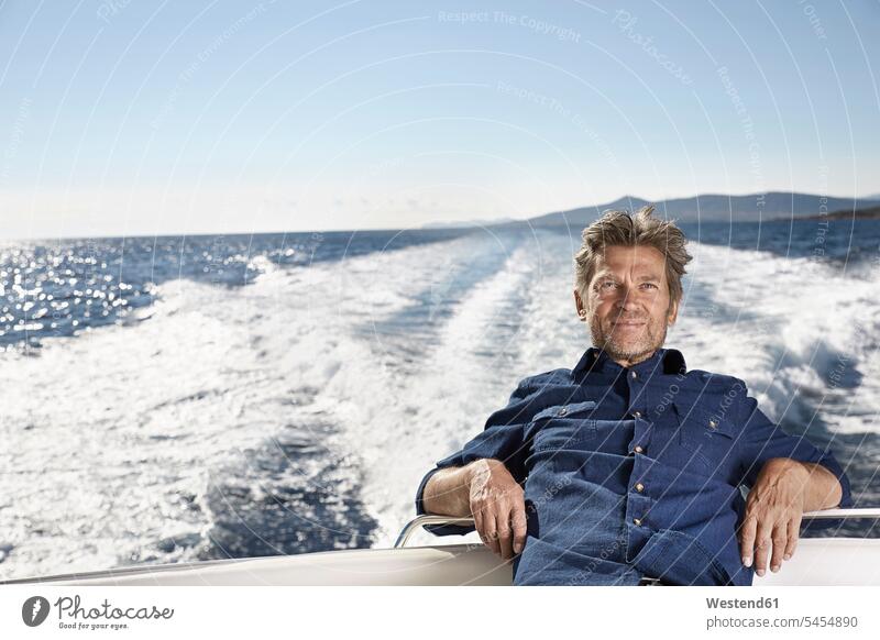 Portrait of content mature man on his motor yacht portrait portraits men males motor yachts Adults grown-ups grownups adult people persons human being humans