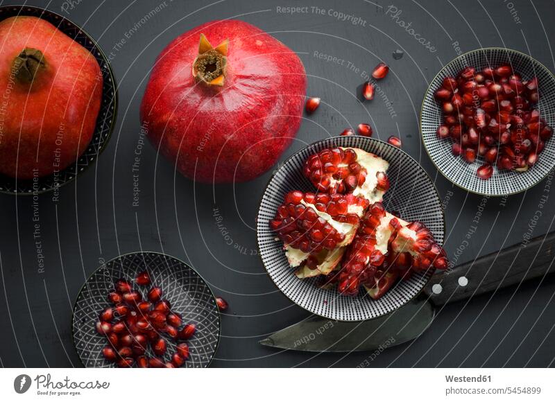 Pomegranate and pomegranate seeds in bowl food and drink Nutrition Alimentation Food and Drinks knife knives overhead view from above top view Overhead