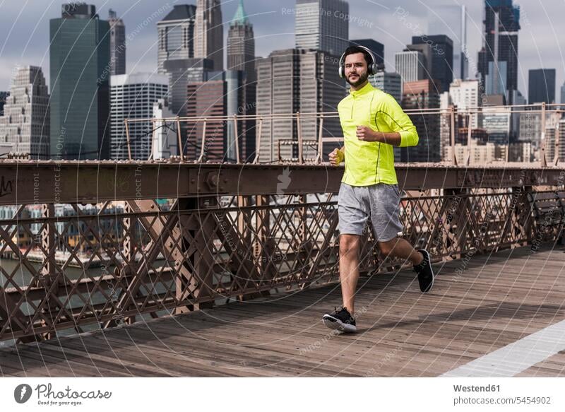 USA, New York City, man running on Brooklyn Brige Jogging headphones headset men males bridge bridges fitness sport sports Adults grown-ups grownups adult
