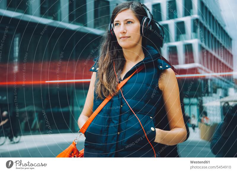 Young woman with headphones in the city music headset females women Adults grown-ups grownups adult people persons human being humans human beings town cities
