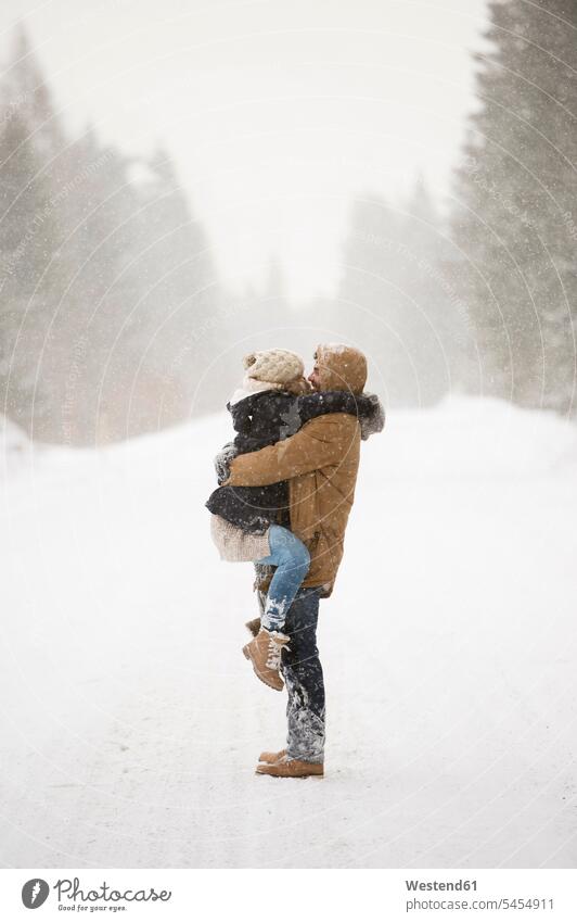 Happy young couple face to face in snow-covered winter landscape winter landscapes twosomes partnership couples scenery terrain people persons human being