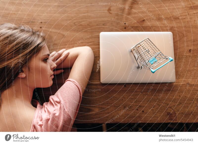 Young woman looking at shopping cart on laptop, shopping online young Laptop Computers laptops notebook females women buying Internet The Internet technology