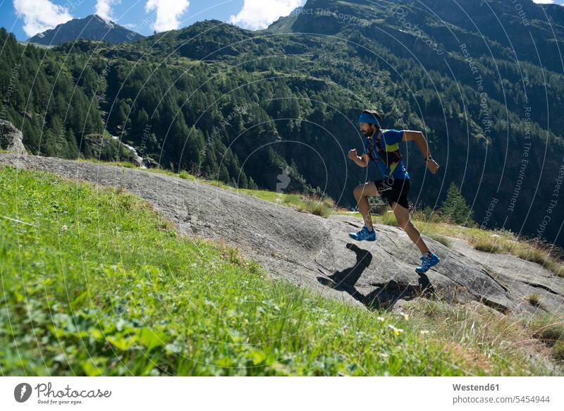 Italy, Alagna, trail runner on the move near Monte Rosa mountain massif athlete Sportspeople Sportsman Sportsperson athletes Sportsmen males running mountains