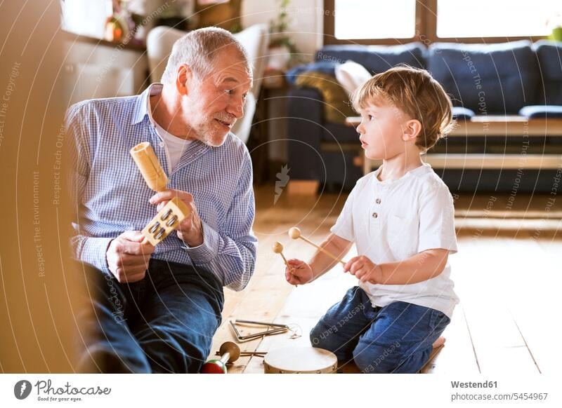 Grandfather and grandson playing music at home learning grandsons together grandfather grandpas granddads grandfathers practicing practice practise exercise