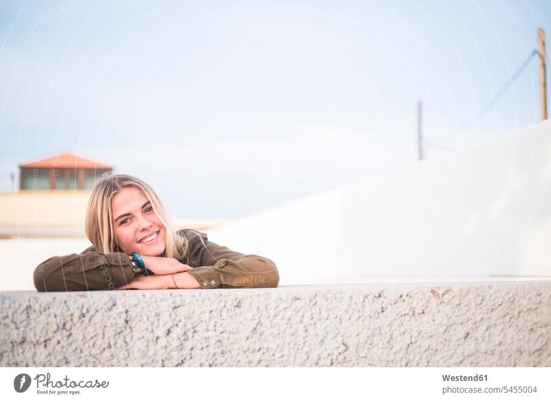 Spain, Tenerife, portrait of young blond woman leaning on wall portraits females women Adults grown-ups grownups adult people persons human being humans