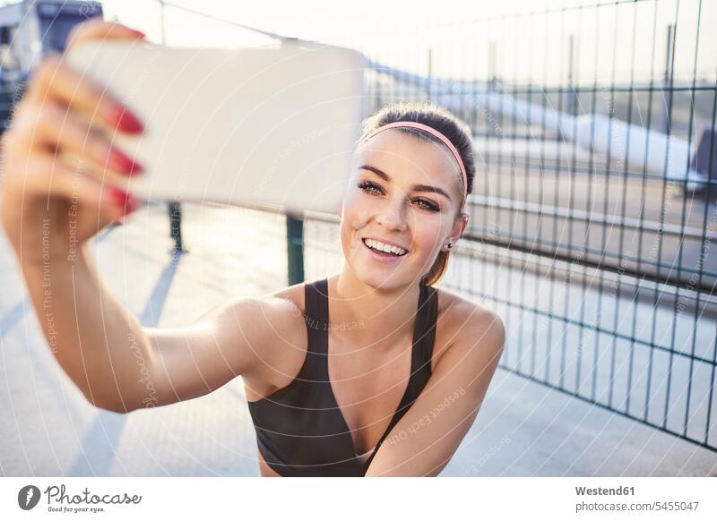 Fit woman taking selfie after outdoor workout females women mobile phone mobiles mobile phones Cellphone cell phone cell phones working out work out urban