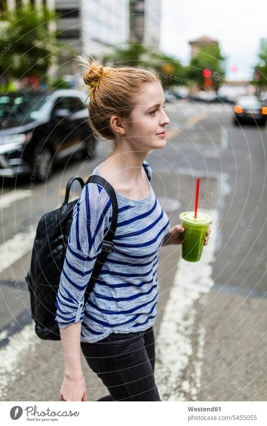 USA, New York City, woman holding a smoothie walking on the streets of Manhattan females women going Smoothies Adults grown-ups grownups adult people persons
