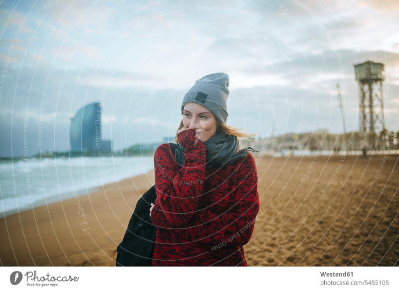 Spain, Barcelona, young woman on the beach in winter smiling smile females women beaches Adults grown-ups grownups adult people persons human being humans