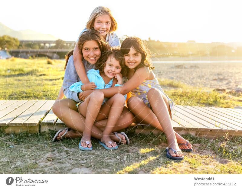 Group picture of four girls sitting on boardwalk in summer females female friends group picture Group Portrait group foto child children kid kids people persons