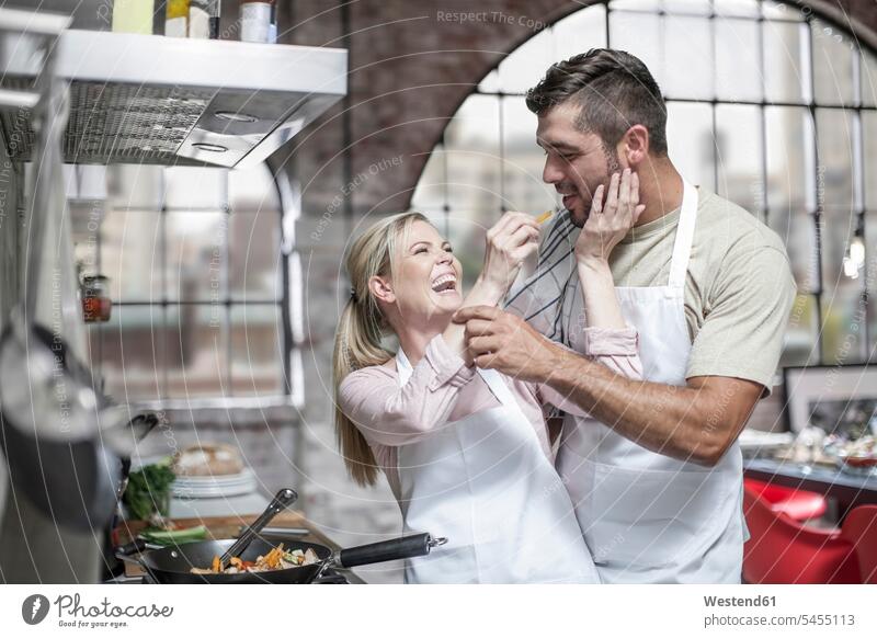 Couple cooking together and having fun in kitchen Fun funny laughing Laughter couple twosomes partnership couples eating positive Emotion Feeling Feelings