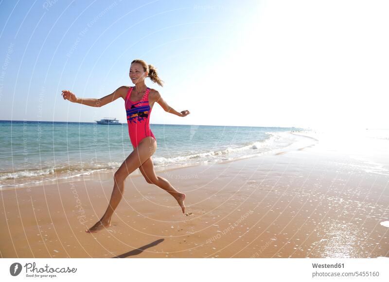 Egypt, Soma Bay, happy woman running on the beach females women beaches Adults grown-ups grownups adult people persons human being humans human beings vacation