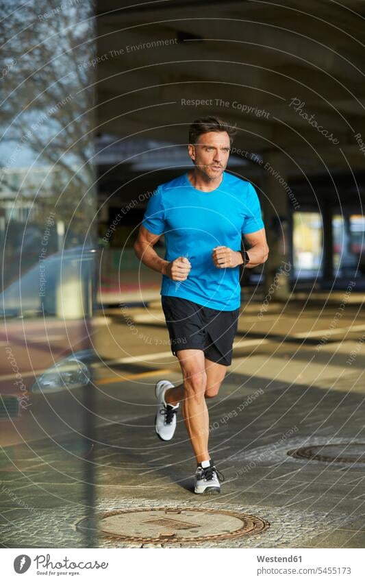 Man running in the city town cities towns exercising exercise training practising urban urbanity Jogging athlete Sportspeople Sportsman Sportsperson athletes