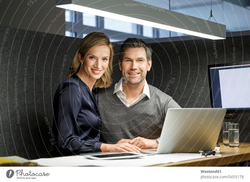 Portrait of smiling businesswoman and businessman with laptop in meeting box Laptop Computers laptops notebook smile office offices office room office rooms