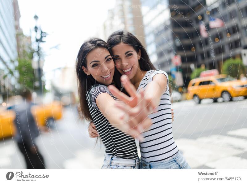 USA, New York City, portrait of two beautiful twin sisters in Manhattan having fun Fun funny female friends New York State siblings brother and sister