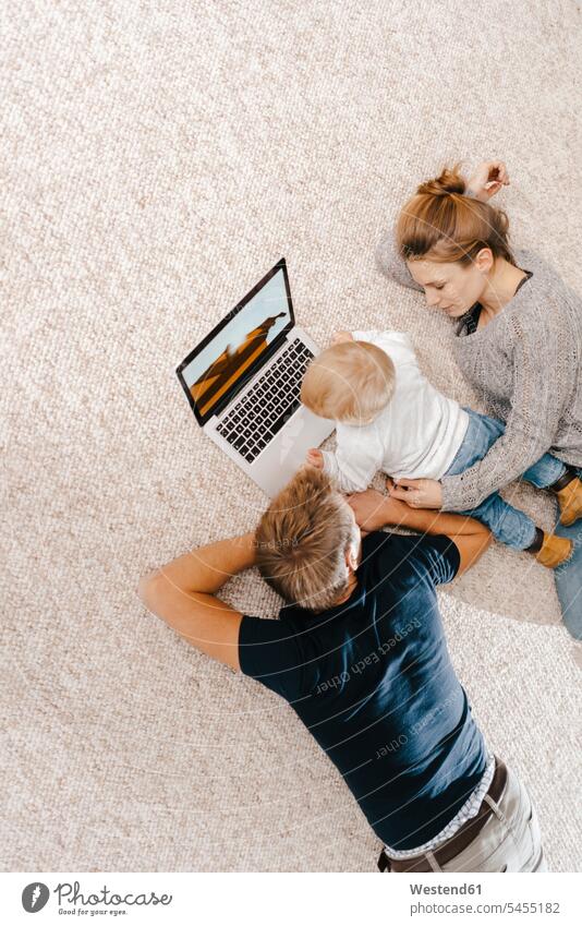 Family using laptop on the carpet carpets rug rugs family families use Laptop Computers laptops notebook people persons human being humans human beings computer
