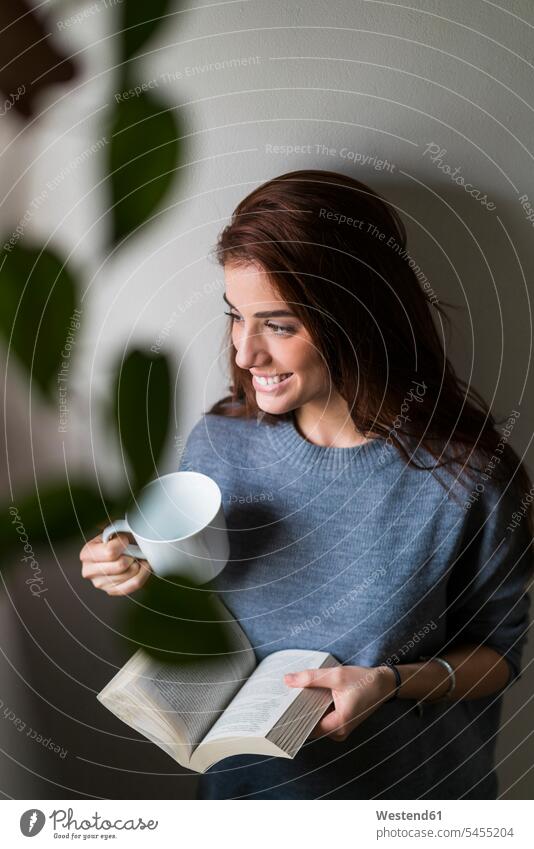 Attractive young woman reading book and drinking coffee books young women daydreaming dreamy Coffee smiling smile attractive beautiful pretty good-looking