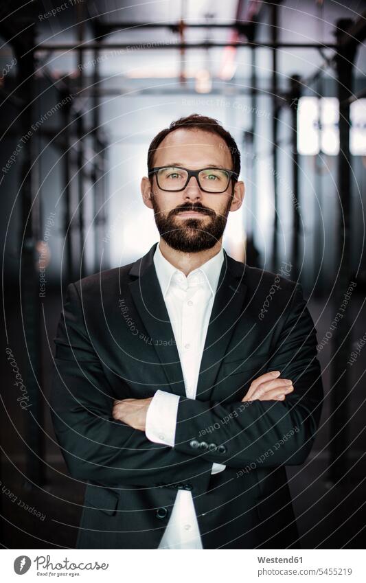 Portrait of an ambitious businessman with crossed arms confidence confident portrait portraits beard glasses specs Eye Glasses spectacles Eyeglasses Businessman