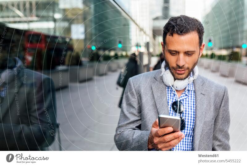 Businessman with headphones and cell phone in the city headset mobile phone mobiles mobile phones Cellphone cell phones Business man Businessmen Business men
