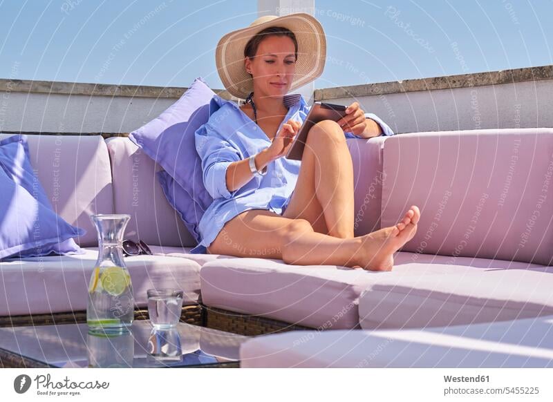Woman with tablet relaxing on sun deck Glass Drinking Glasses vacation Holidays digitizer Tablet Computer Tablet PC Tablet Computers iPad Digital Tablet