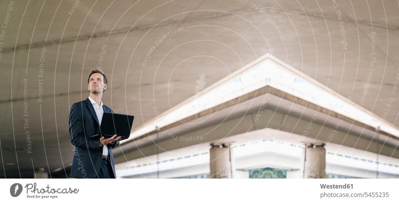 Businessman standing at underpass holding laptop, composite Business man Businessmen Business men Laptop Computers laptops notebook business people