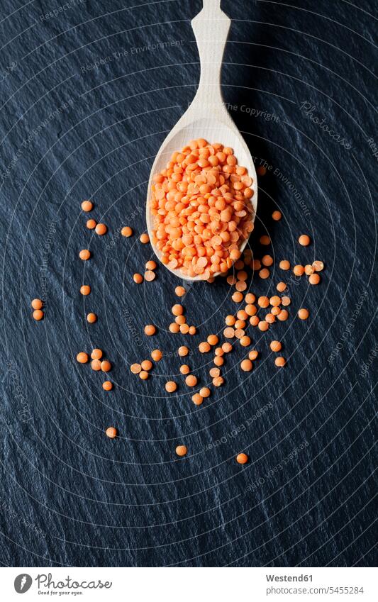Wooden spoon of red lentils on slate food and drink Nutrition Alimentation Food and Drinks close-up close up closeups close ups close-ups orange scattered