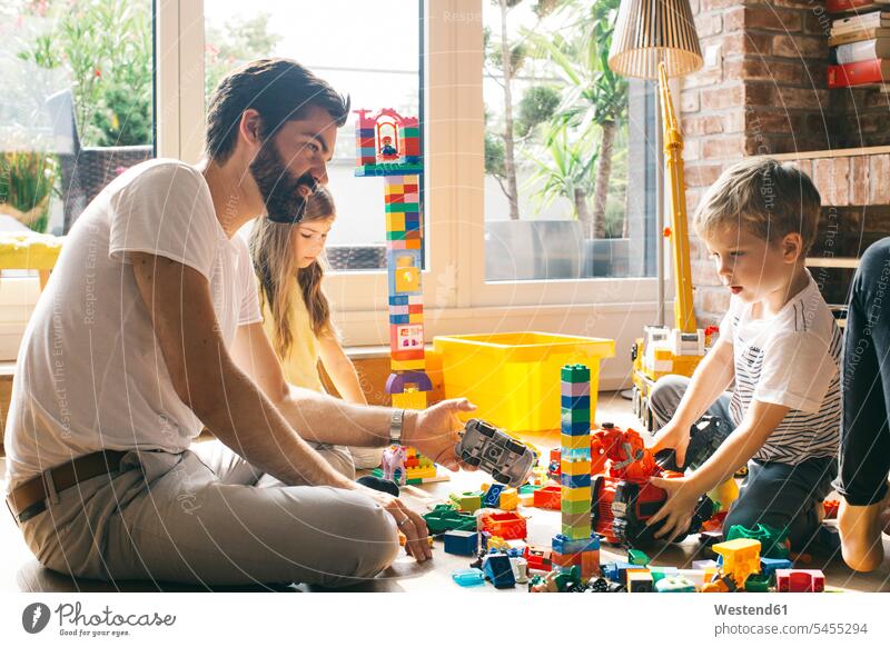 Family playing with building blocks on the floor together family families people persons human being humans human beings home at home skill Skillful Dexterity