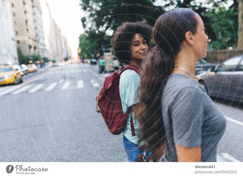 USA, New York City, two friends crossing the street female friends road streets roads mate friendship walking going woman females women smiling smile Adults