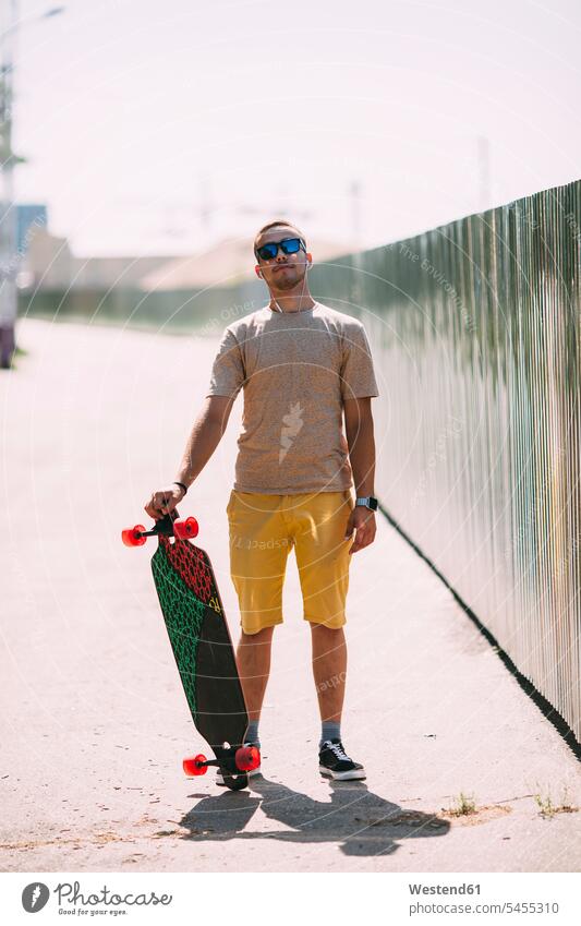 Portrait of confident young man with longboard skateboard Skate Board skateboards standing men males Adults grown-ups grownups adult people persons human being