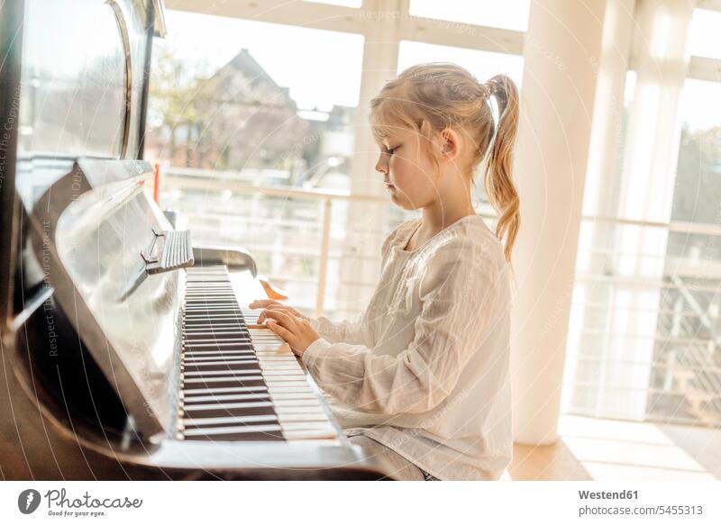 Girl at home playing piano girl females girls pianos child children kid kids people persons human being humans human beings musical instrument