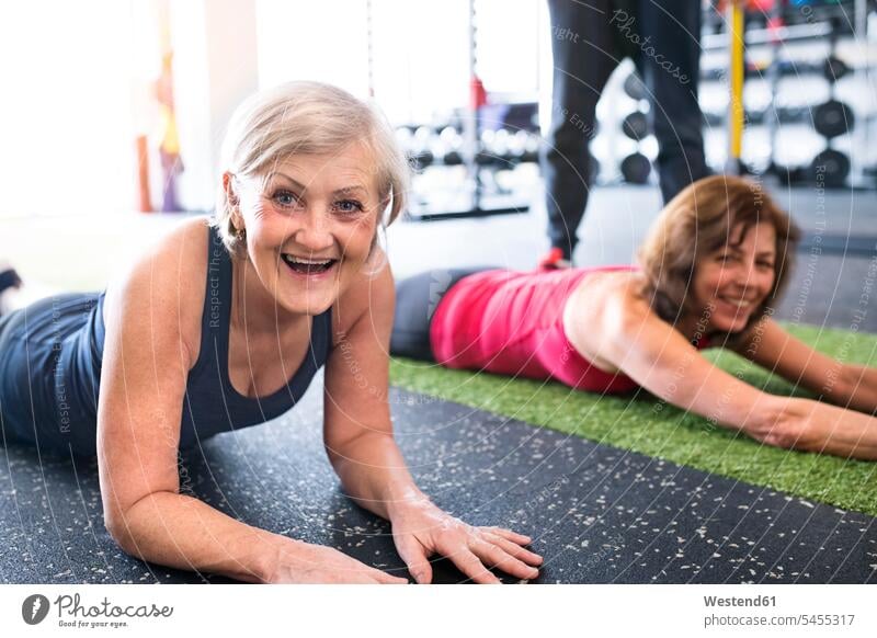 Two fit senior women having fun in gym laughing Laughter exercising exercise training practising elder women elder woman old senior woman gyms Health Club