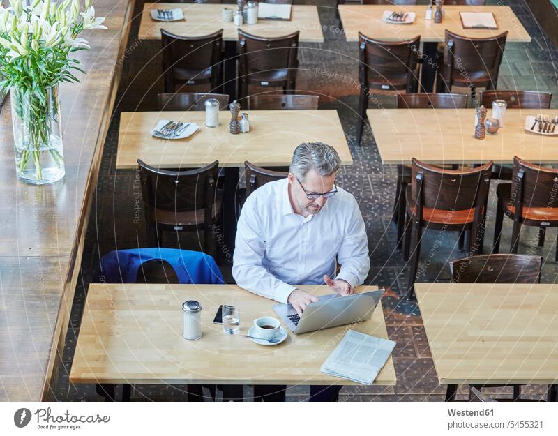 Mature businessman in cafe using laptop working At Work Businessman Business man Businessmen Business men Laptop Computers laptops notebook business people