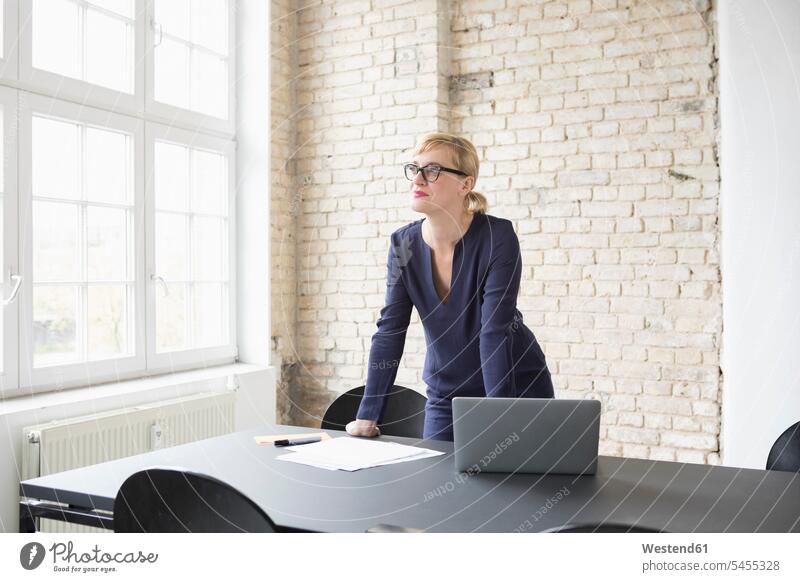 Successful businesswoman standing in her office working At Work laptop Laptop Computers laptops notebook businesswomen business woman business women offices