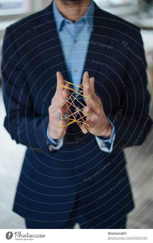 Close-up of businessman holding rubber bands hand human hand hands human hands Businessman Business man Businessmen Business men people persons human being