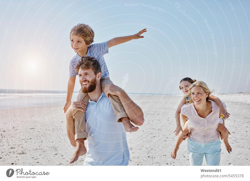 Happy family strolling on the beach smiling smile beaches families happiness happy people persons human being humans human beings vacation Holidays Travel Sea