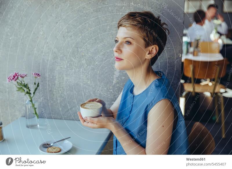 Serious woman with a cup of coffee in a cafe females women Coffee serious earnest Seriousness austere Adults grown-ups grownups adult people persons human being