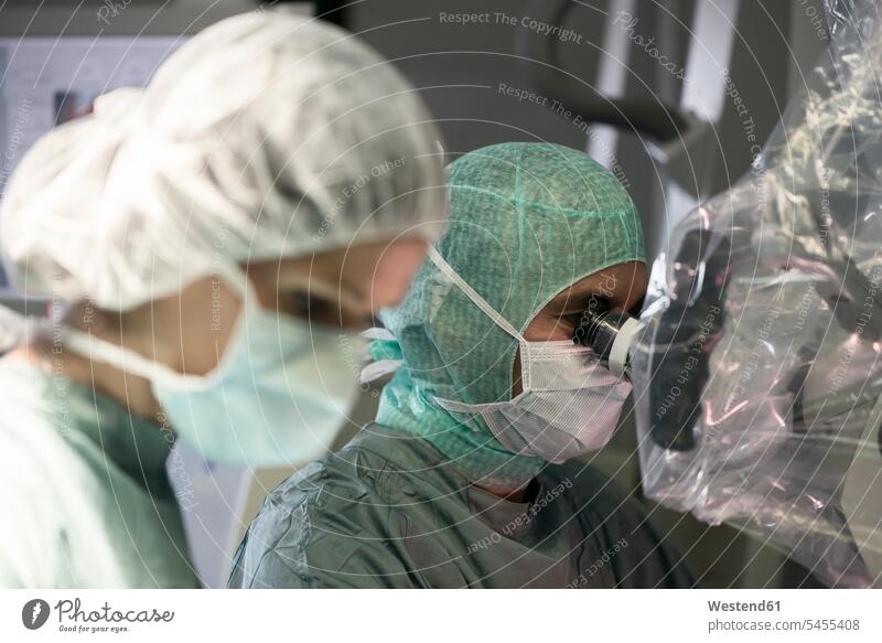 Neurosurgeon and operating room nurse during an operation doctor physicians doctors surgery surgeries healthcare and medicine medical Healthcare And Medicines