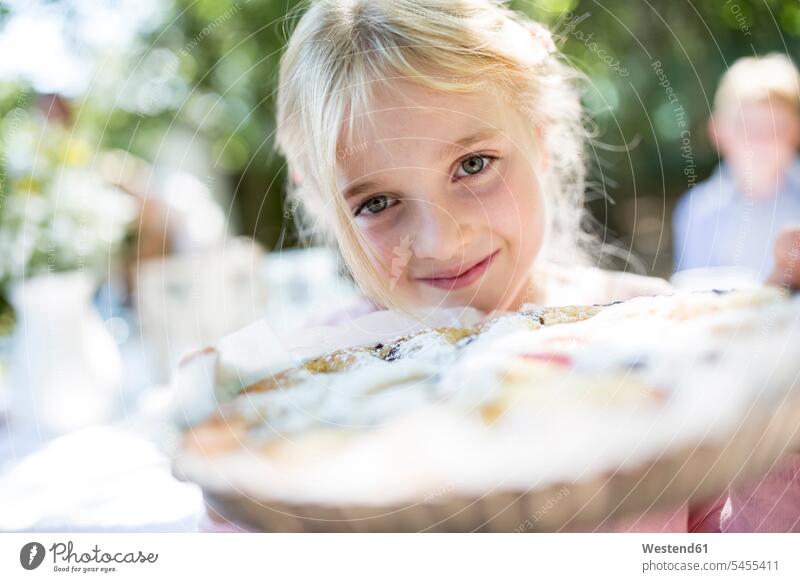 Portrait of smiling girl holding a pie outdoors females girls smile cake pies cakes child children kid kids people persons human being humans human beings