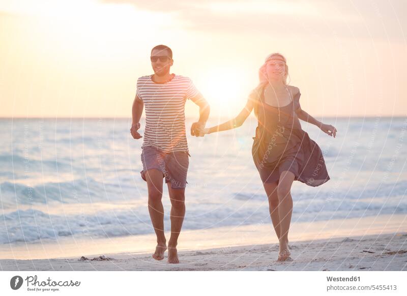 Young couple running on the beach, holding hands vacation Holidays beaches Sea ocean happiness happy getting away from it all Getting Away From All unwinding