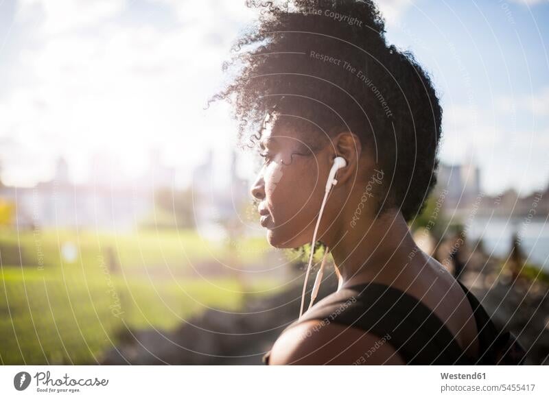 Woman listening to music outdoors earphones ear phone ear phones hearing woman females women earbuds Earbud In-Ear Headphones ear bud Ear buds in-ear headphones